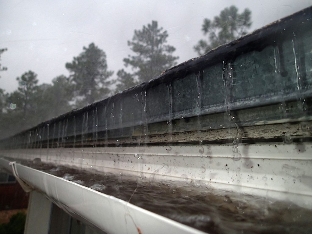 Rainwater flowing along a roof gutter